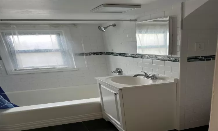 Bathroom featuring shower / bath combination with curtain, vanity, and tile patterned floors