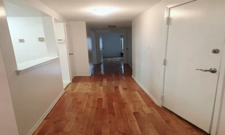 Corridor with light hardwood / wood-style flooring