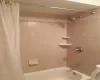 Bathroom with toilet and shower / bathtub combination with curtain