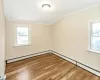 Unfurnished bedroom featuring light wood-type flooring, baseboard heating, and ornamental molding