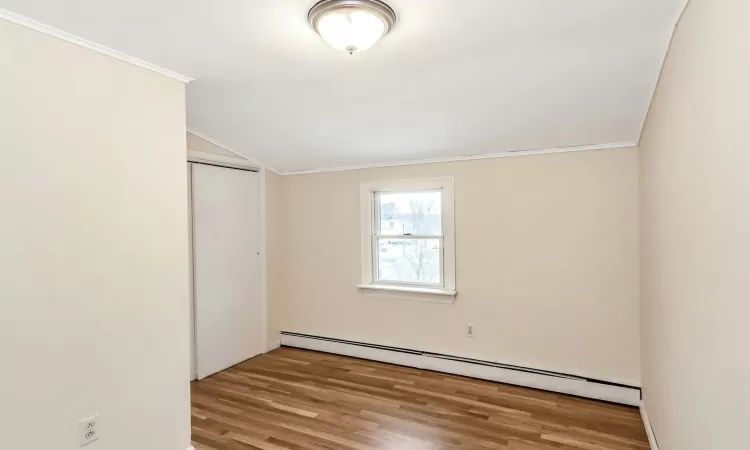 Empty room featuring plenty of natural light, light hardwood / wood-style floors, and baseboard heating