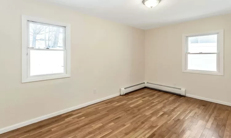 Unfurnished bedroom featuring ornamental molding, light wood-type flooring, and multiple closets