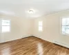 Unfurnished living room featuring crown molding, light hardwood / wood-style floors, and an inviting chandelier