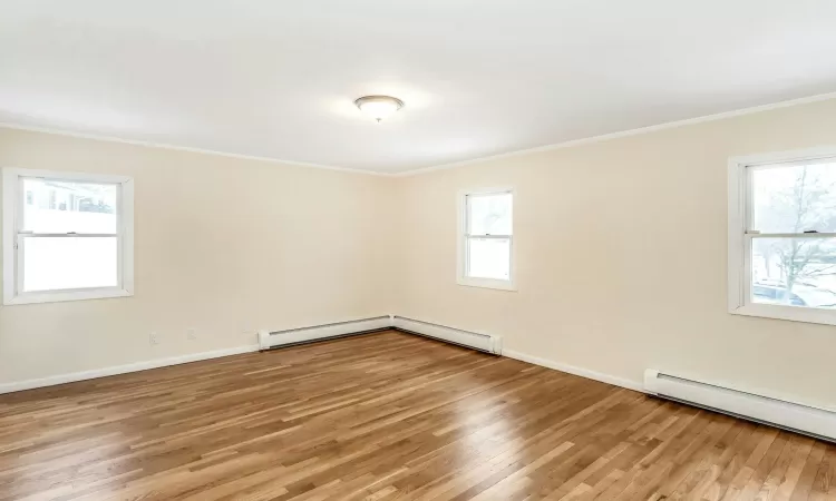 Unfurnished living room featuring crown molding, light hardwood / wood-style floors, and an inviting chandelier