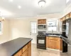 Kitchen featuring black gas range, crown molding, sink, decorative backsplash, and a chandelier