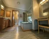 Bathroom featuring ceiling fan, wood-type flooring, a textured ceiling, vanity, and ornamental molding