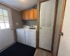 Clothes washing area with cabinets, separate washer and dryer, a textured ceiling, and light hardwood / wood-style flooring