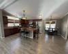 Kitchen featuring ventilation hood, vaulted ceiling, a breakfast bar, a kitchen island, and appliances with stainless steel finishes