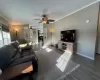 Living room featuring a textured ceiling, ceiling fan, crown molding, and dark hardwood / wood-style floors