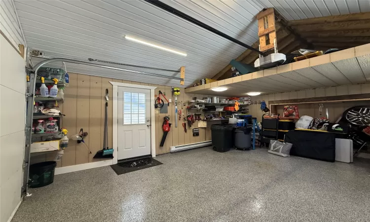 Garage with a workshop area, wood walls, and a garage door opener