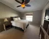 Bedroom featuring a textured ceiling, ceiling fan, carpet floors, and crown molding