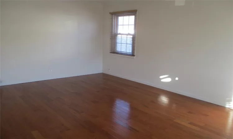 Empty room with dark wood-type flooring