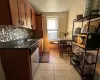 Kitchen featuring decorative backsplash, sink, light tile patterned floors, and stainless steel appliances