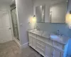 Bathroom featuring decorative backsplash, vanity, and walk in shower