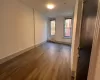 Unfurnished room with wood-type flooring and radiator heating unit