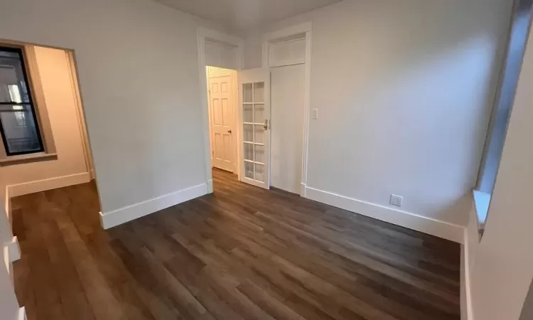 Empty room featuring dark wood-type flooring