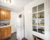 Kitchen with white fridge, dark tile patterned floors, and tasteful backsplash