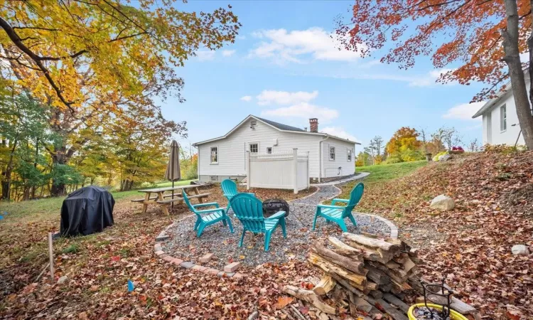 Rear view of property with a fire pit