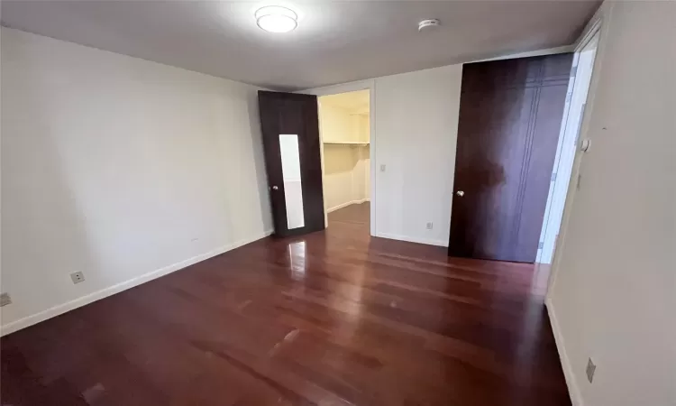 Unfurnished bedroom with a walk in closet and a closet