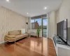 Living room featuring hardwood / wood-style flooring and an AC wall unit