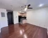 Kitchen with black fridge, dark hardwood / wood-style flooring, range with electric stovetop, electric panel, and light brown cabinetry