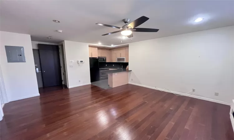 Kitchen with black fridge, dark hardwood / wood-style flooring, range with electric stovetop, electric panel, and light brown cabinetry