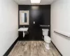 Bathroom with a paneled ceiling, toilet, and sink