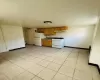 Kitchen with sink, light tile patterned floors, and white appliances