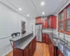 Kitchen with a kitchen breakfast bar, light wood-type flooring, sink, a center island, and stainless steel refrigerator