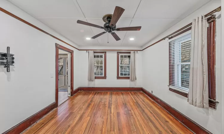 Empty room featuring ceiling fan and dark wood-type flooring