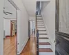 Stairs featuring hardwood / wood-style flooring, ceiling fan, crown molding, and radiator