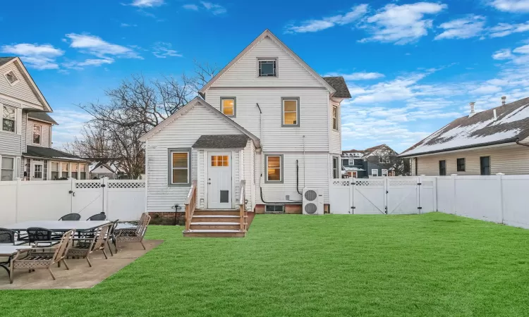 Rear view of house featuring a lawn and a patio