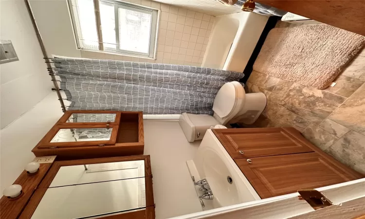 Full bathroom featuring shower / tub combo with curtain, vanity, and toilet