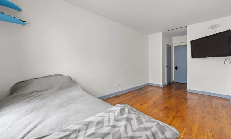 Unfurnished bedroom featuring dark wood-type flooring