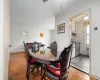 Dining area with hardwood / wood-style floors, ceiling fan, tile walls, and radiator