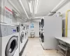 Clothes washing area featuring washing machine and dryer, light tile patterned floors, and stacked washer and dryer