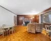 Living room featuring light parquet flooring, a stone fireplace, and wooden walls