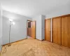 Unfurnished bedroom with multiple closets and light parquet flooring