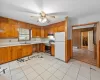 Kitchen featuring a baseboard heating unit, white refrigerator, electric stove, sink, and ceiling fan