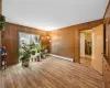 Living area featuring wood walls, wood-type flooring, and a baseboard heating unit