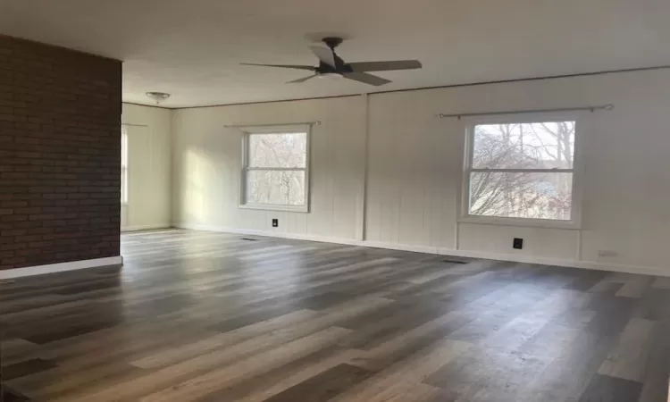 Unfurnished room featuring ceiling fan and dark wood-type flooring