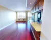 View of Open Concept Living with, Wall of Windows, Entry to Balcony, Room Featuring Crown Molding and Dark Hardwood   Flooring