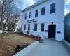 Colonial home with ac unit, a wall mounted air conditioner, and a front yard