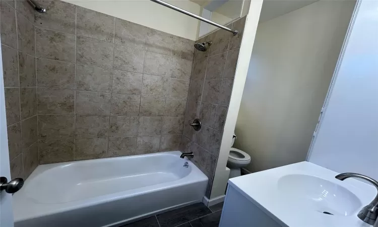 Full bathroom with tile patterned flooring, vanity, toilet, and tiled shower / bath