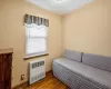 Sitting room featuring radiator heating unit and wood-type flooring