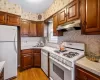 Kitchen featuring decorative backsplash, sink, light hardwood / wood-style floors, and white appliances