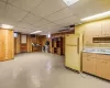 Kitchen with white fridge, a drop ceiling, wooden walls, and sink