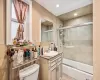 Full bathroom featuring vanity, toilet, and shower / bath combination with glass door