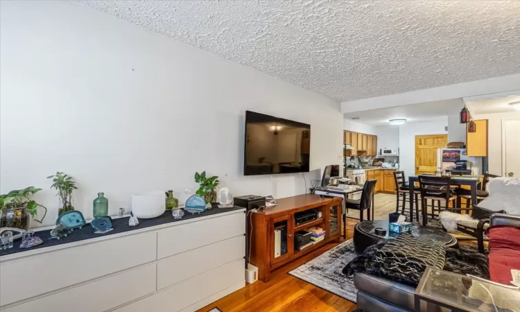 Living room featuring a textured ceiling and light hardwood / wood-style flooring