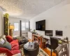 Living room with radiator heating unit, a textured ceiling, hardwood / wood-style flooring, and lofted ceiling